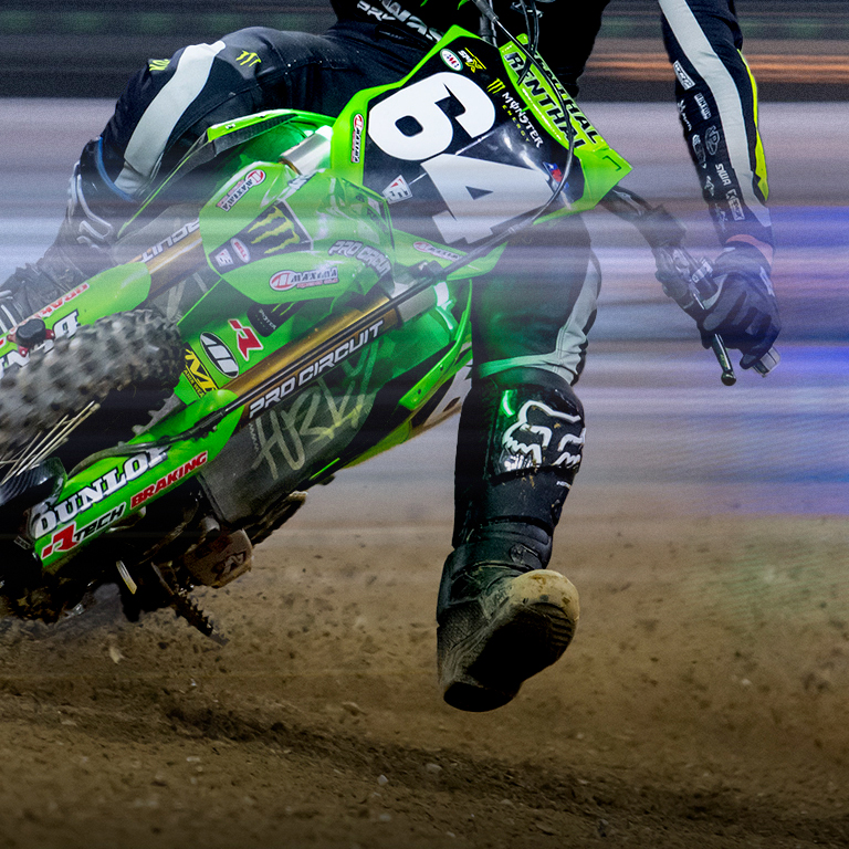 Close-up of the rider boots as he leans the bike into a dirt.